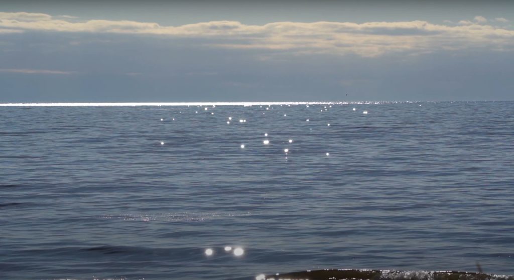 Blue ocean water with clouds